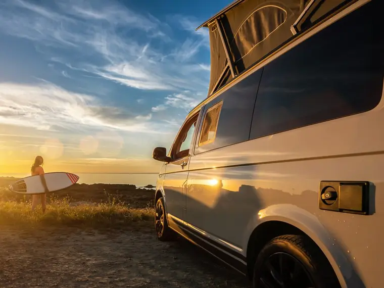 Campervan parked by the coast at sunset