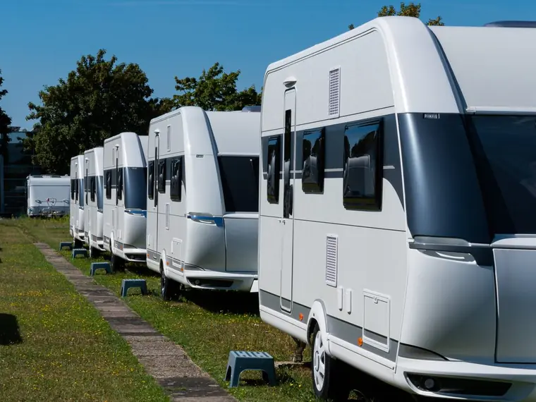 Row of touring caravans parked on grass
